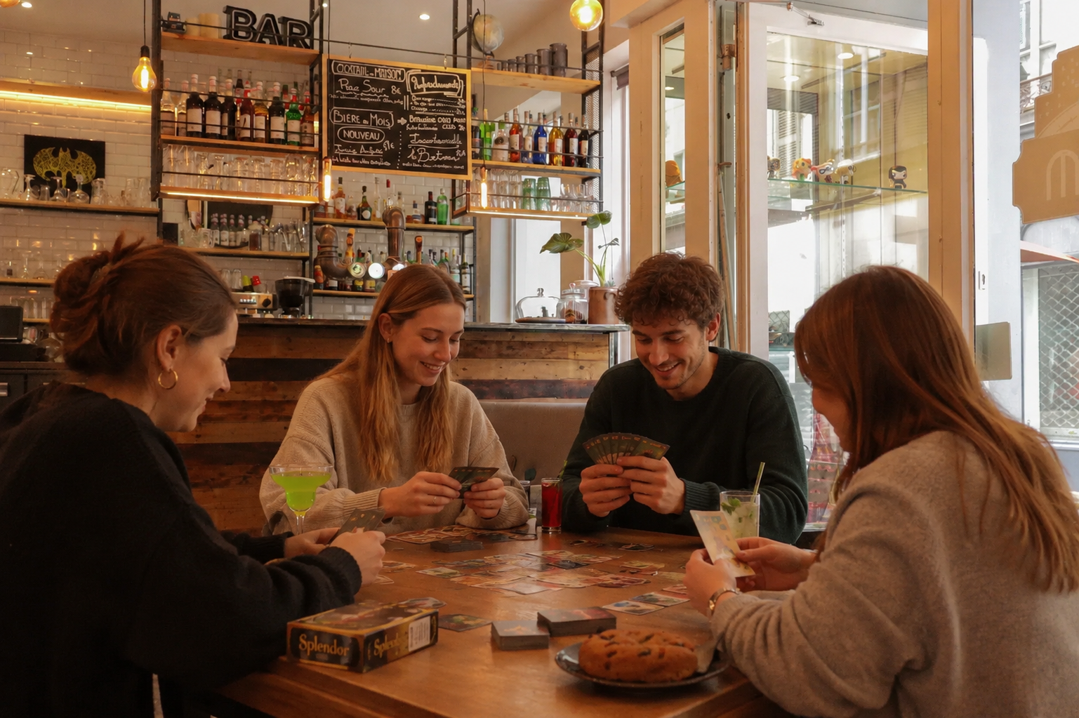 Photo d'une bande d'amis jouant aux cartes dans un bar.